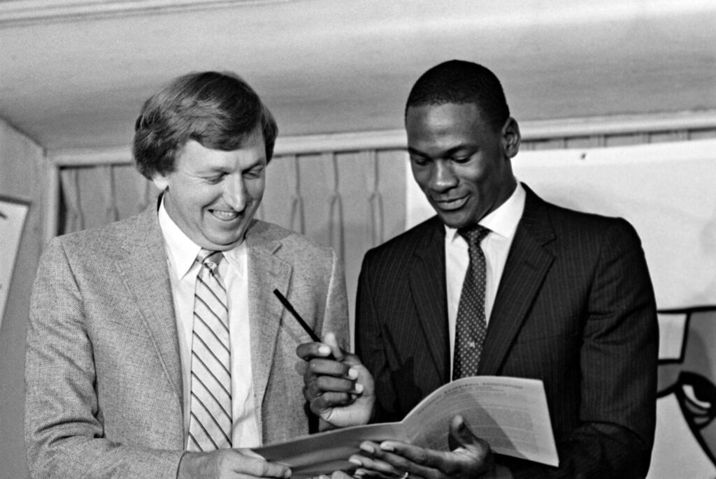 Michael Jordan, with Chicago Bulls general manager Rod Thorn, signed his first NBA contract in 1984.